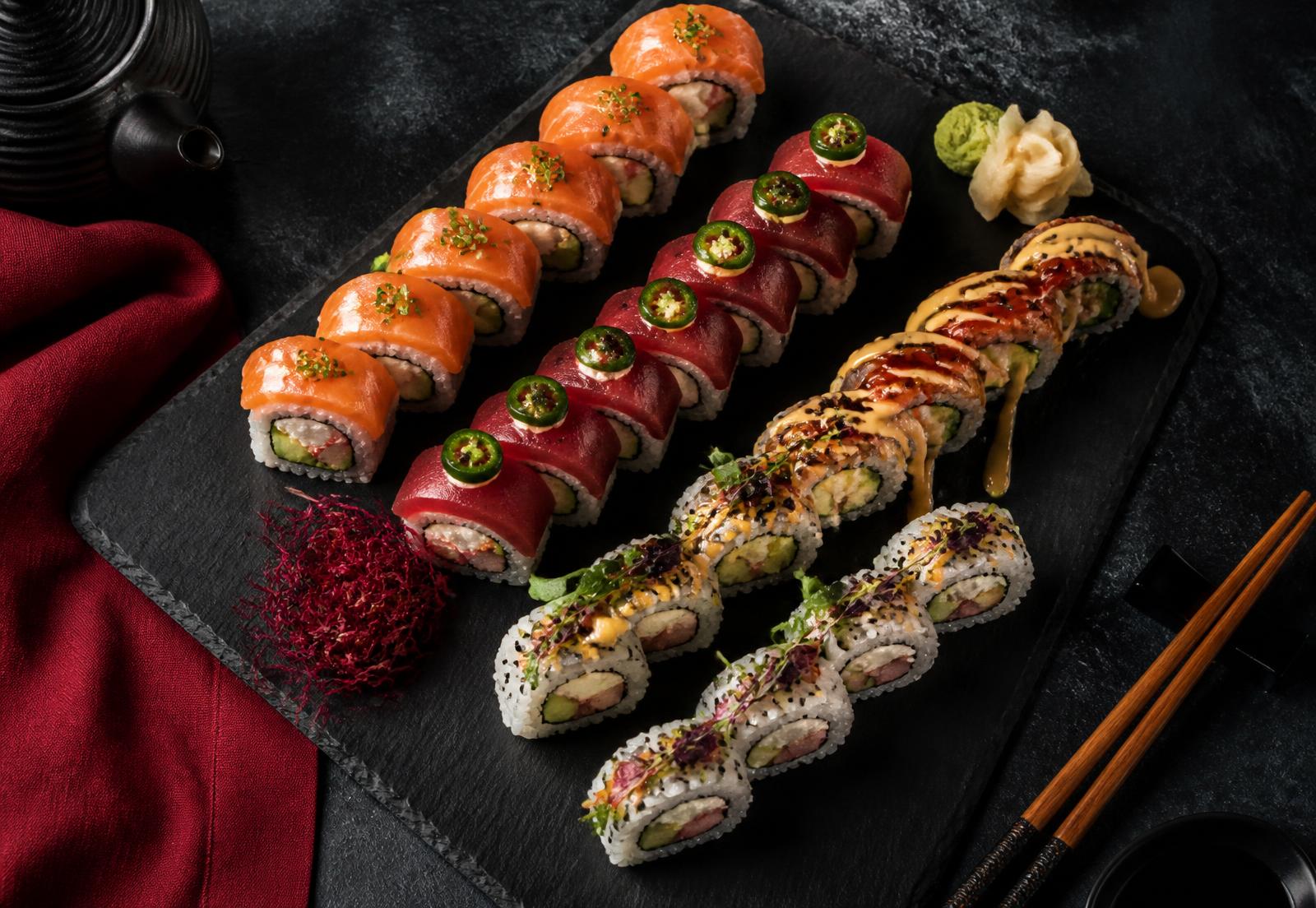 Assorted premium sushi rolls on a black slate board